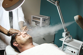 Esthetician performing a facial treatment with steam